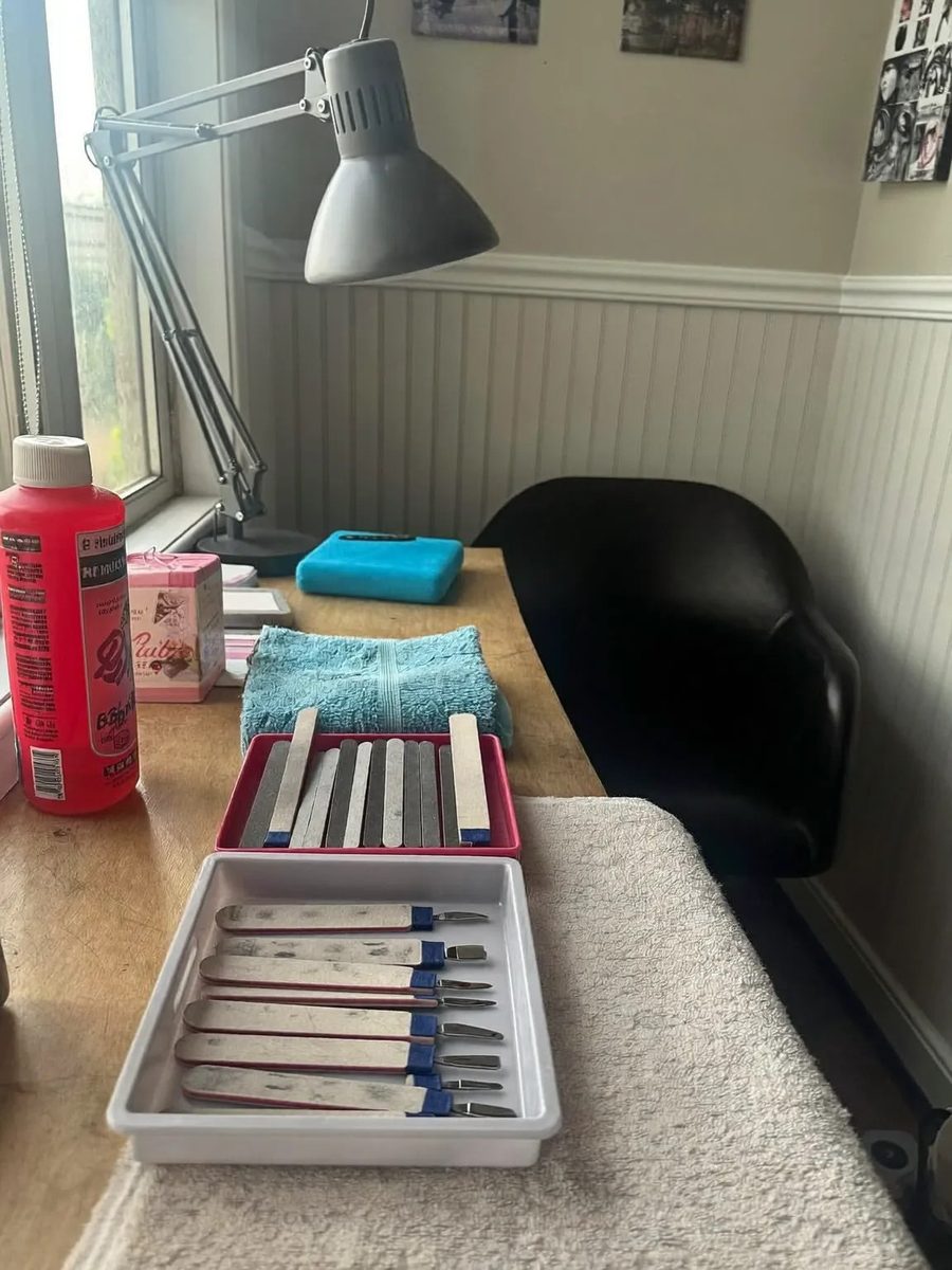 A manicure table and client chair in the salon, with a tray of tools