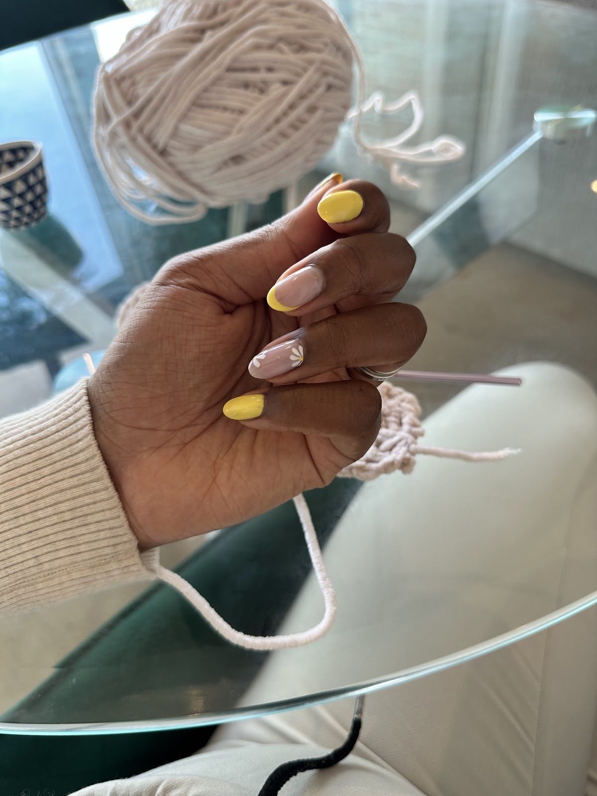 Mix-and-match yellow and nude almond nails beside crochet yarn